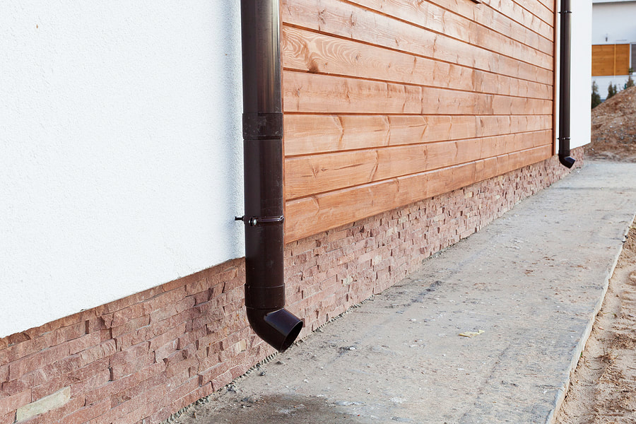 gutter pipe beside the wood wall